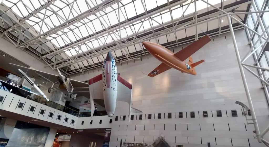 Historic aircraft including the Bell X-1 and SpaceShipOne hanging from the glass ceiling of the Air and Space Museum's main hall
