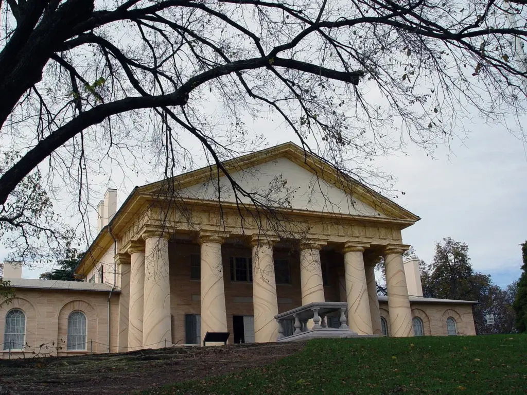 Arlington House's columned portico on the ridge above the cemetery, framed by bare branches