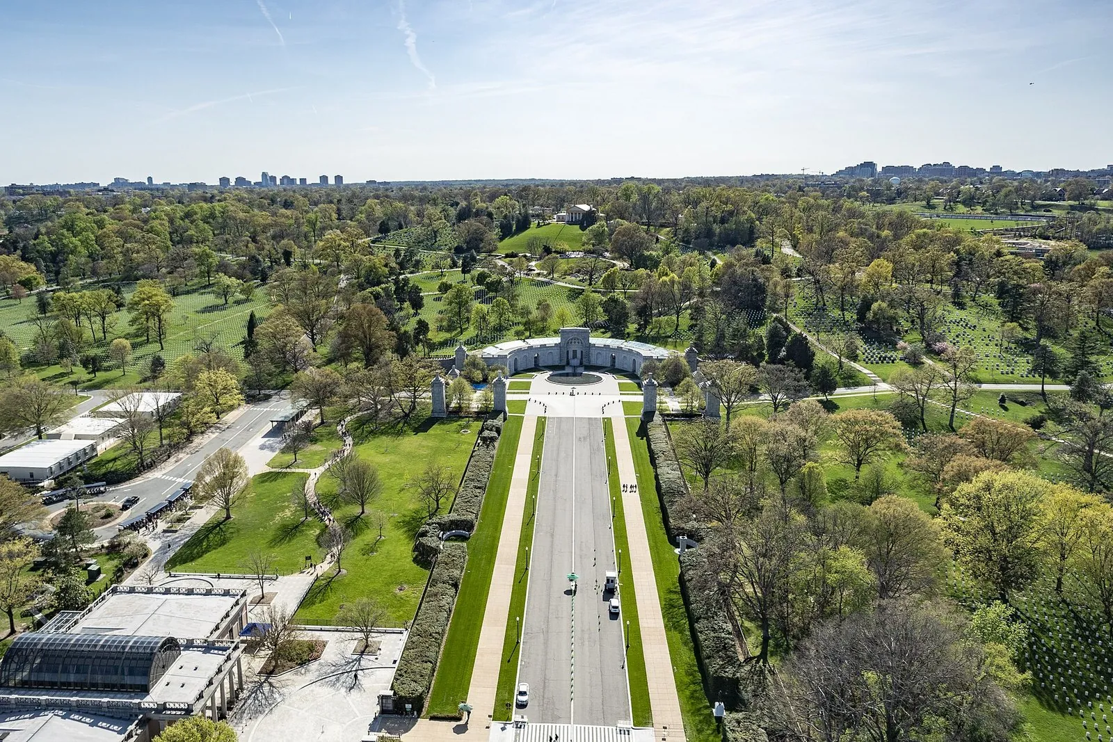 Aerial view of Arlington National Cemetery with Memorial Avenue leading to the Military Women's Memorial and wooded burial sections beyond