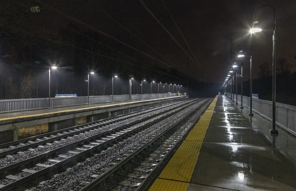 The empty platforms of the BWI Airport rail station at night, lit by a long row of lamps