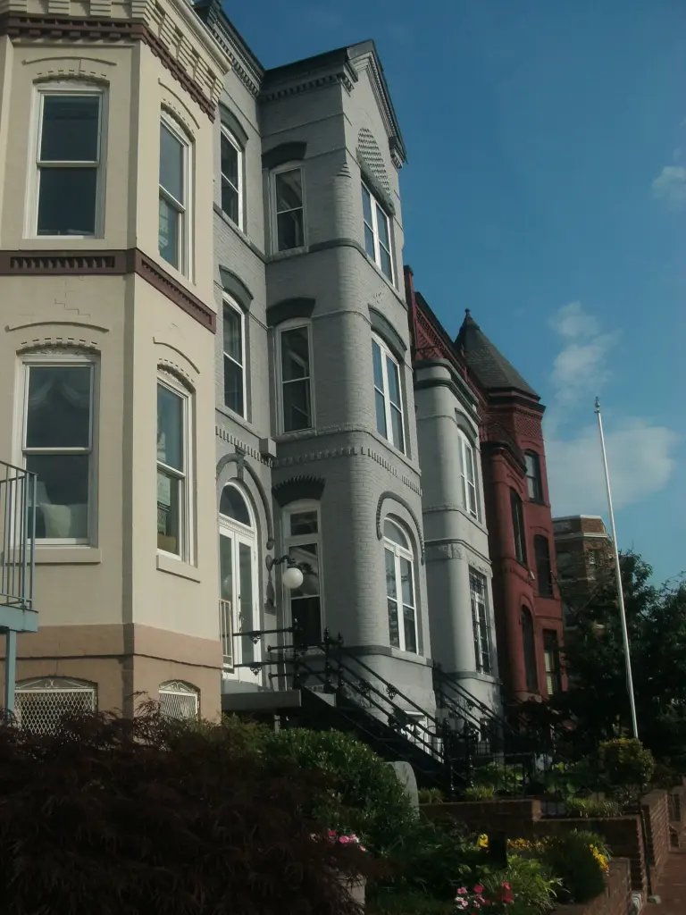 Tall painted rowhouses with bay windows along a Capitol Hill street