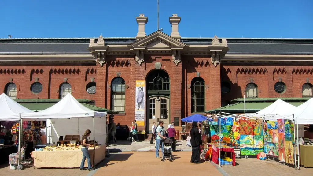 Craft and produce stalls under white tents outside the red-brick Eastern Market hall on Capitol Hill