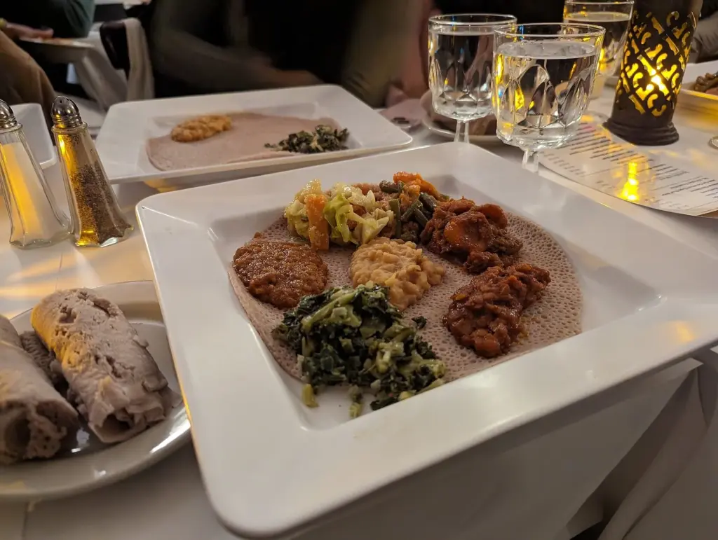 An Ethiopian vegetarian sampler of stews and greens served on injera flatbread