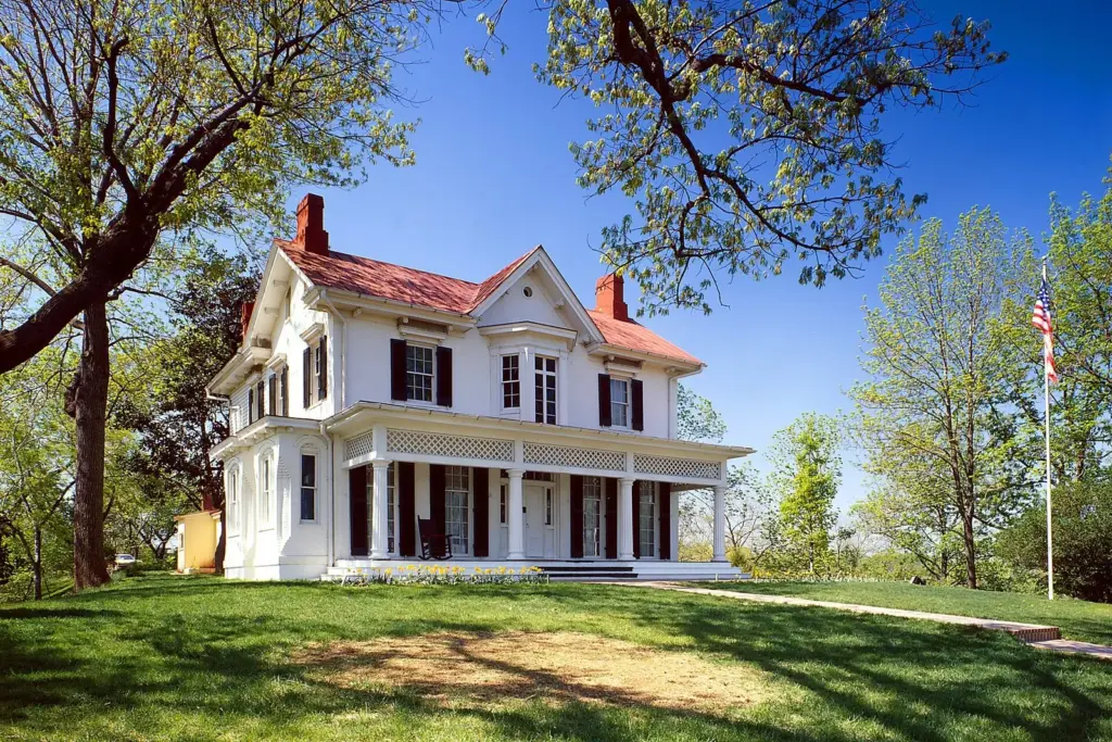 Frederick Douglass's white house at Cedar Hill with a red roof and long porch on a grassy hill