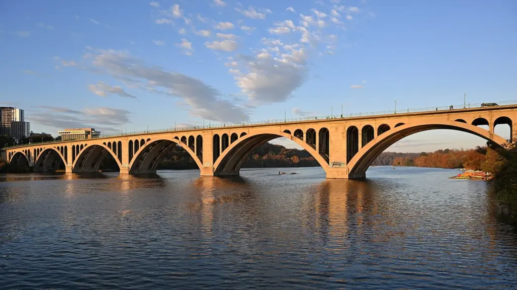 Key Bridge arching across the Potomac River in early morning light, seen from the Georgetown waterfront