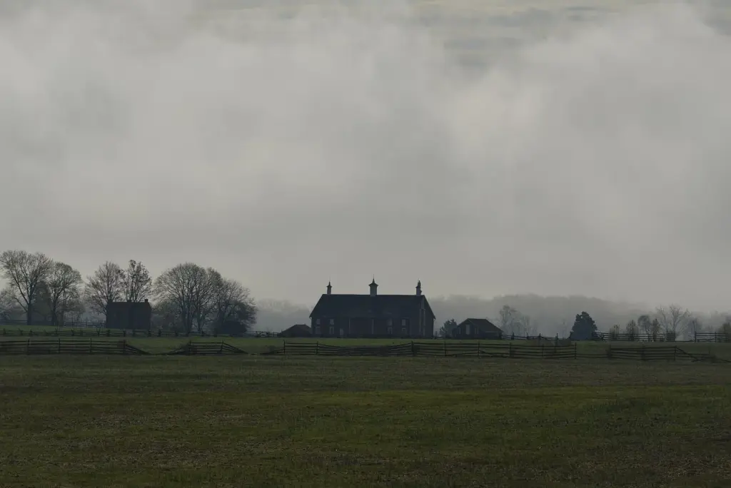 Mist over open fields and a lone farmhouse on the Gettysburg battlefield