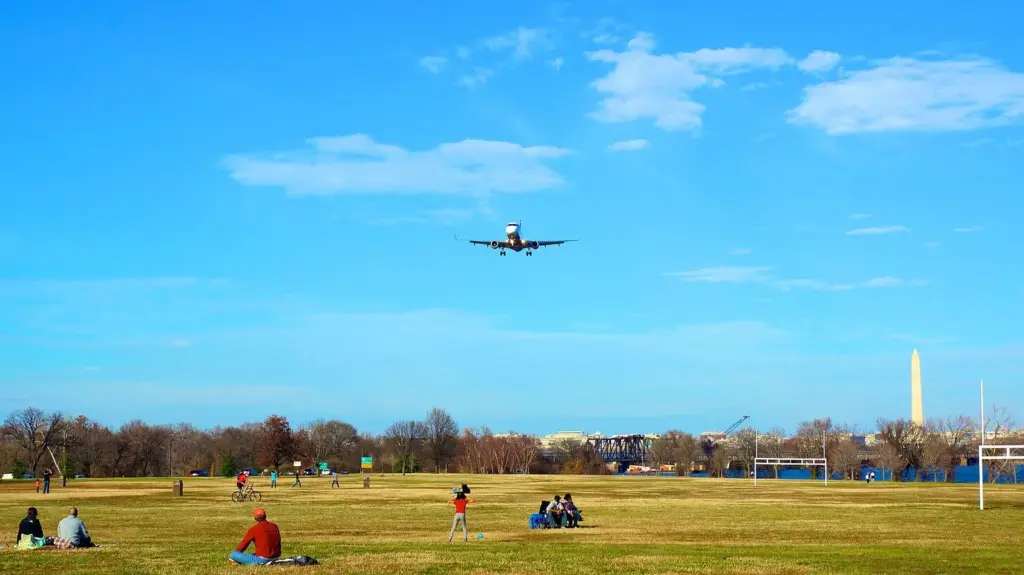 A jet passing low over the lawn at Gravelly Point with the Washington Monument on the skyline