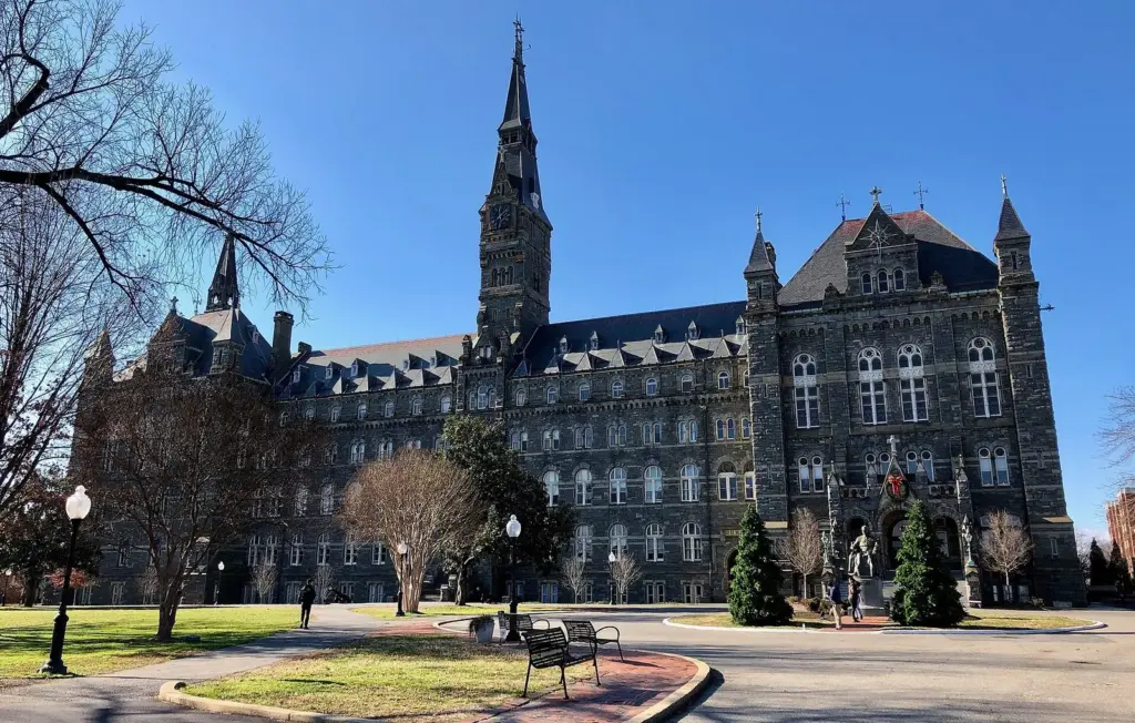 Healy Hall's stone facade and clock tower at Georgetown University under a blue sky