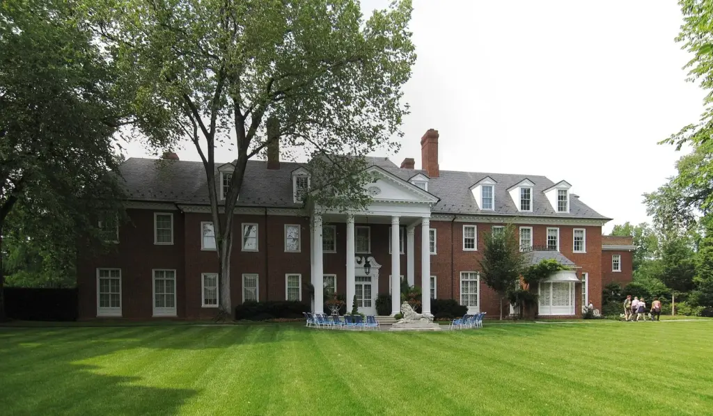Hillwood mansion's columned brick facade behind a wide striped lawn