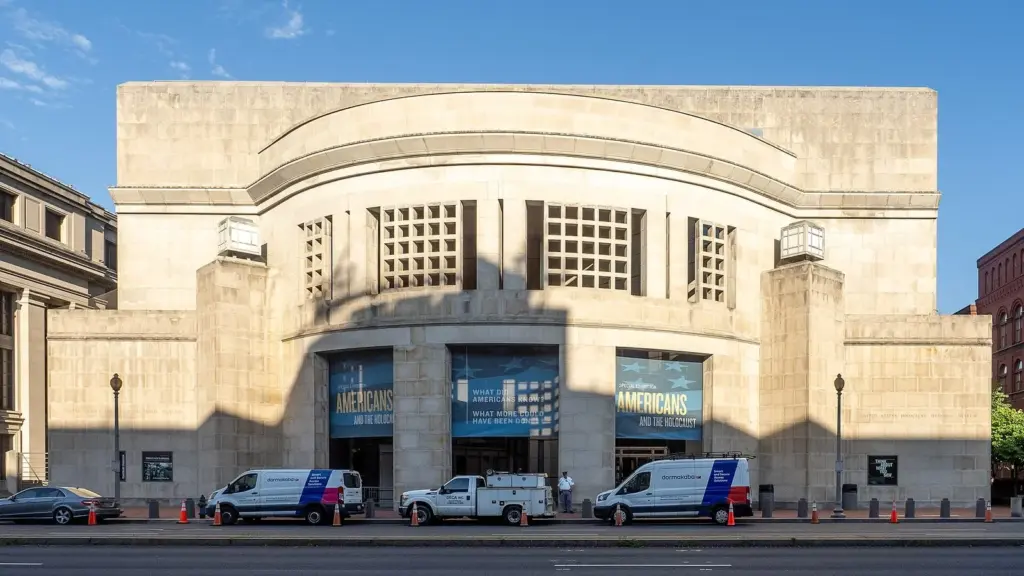 The pale limestone facade of the Holocaust Memorial Museum on 14th Street under a blue sky