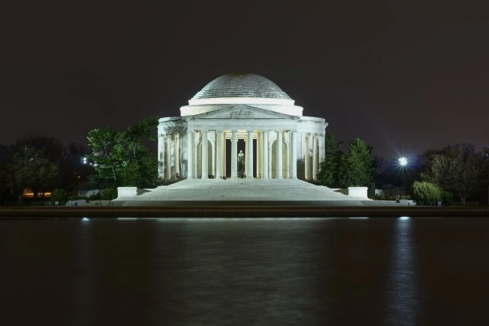 The Jefferson Memorial lit at night across the dark Tidal Basin, a regular stop on Washington DC tours after dark