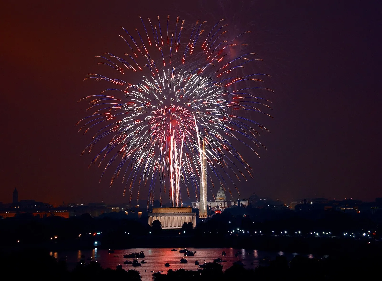Events in Washington DC: Independence Day fireworks bursting over the National Mall, with the Lincoln Memorial, Washington Monument and Capitol lit below