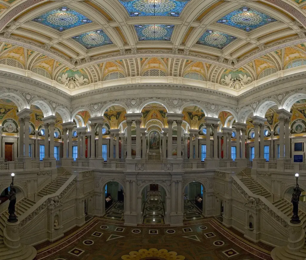 The Great Hall of the Library of Congress Thomas Jefferson Building, with marble staircases, arches and a painted, coffered ceiling