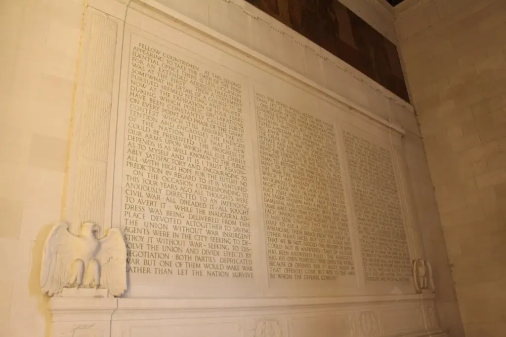 Three columns of Lincoln's Second Inaugural Address carved into the limestone wall, with a carved eagle below and a mural above