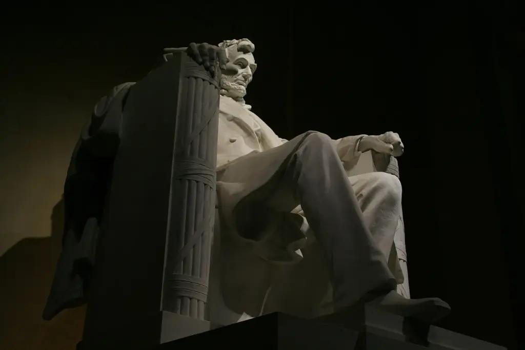 The seated marble statue of Abraham Lincoln, lit dramatically against the chamber wall