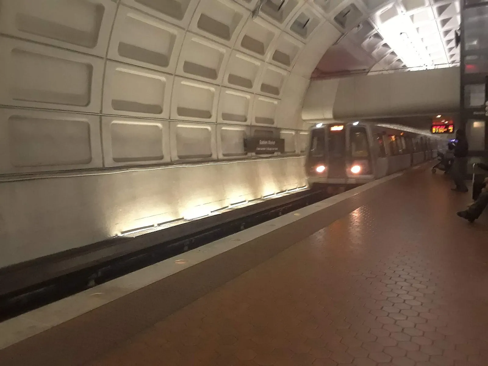 Getting around Washington DC: a Metro train arriving under the coffered concrete vault of Eastern Market station