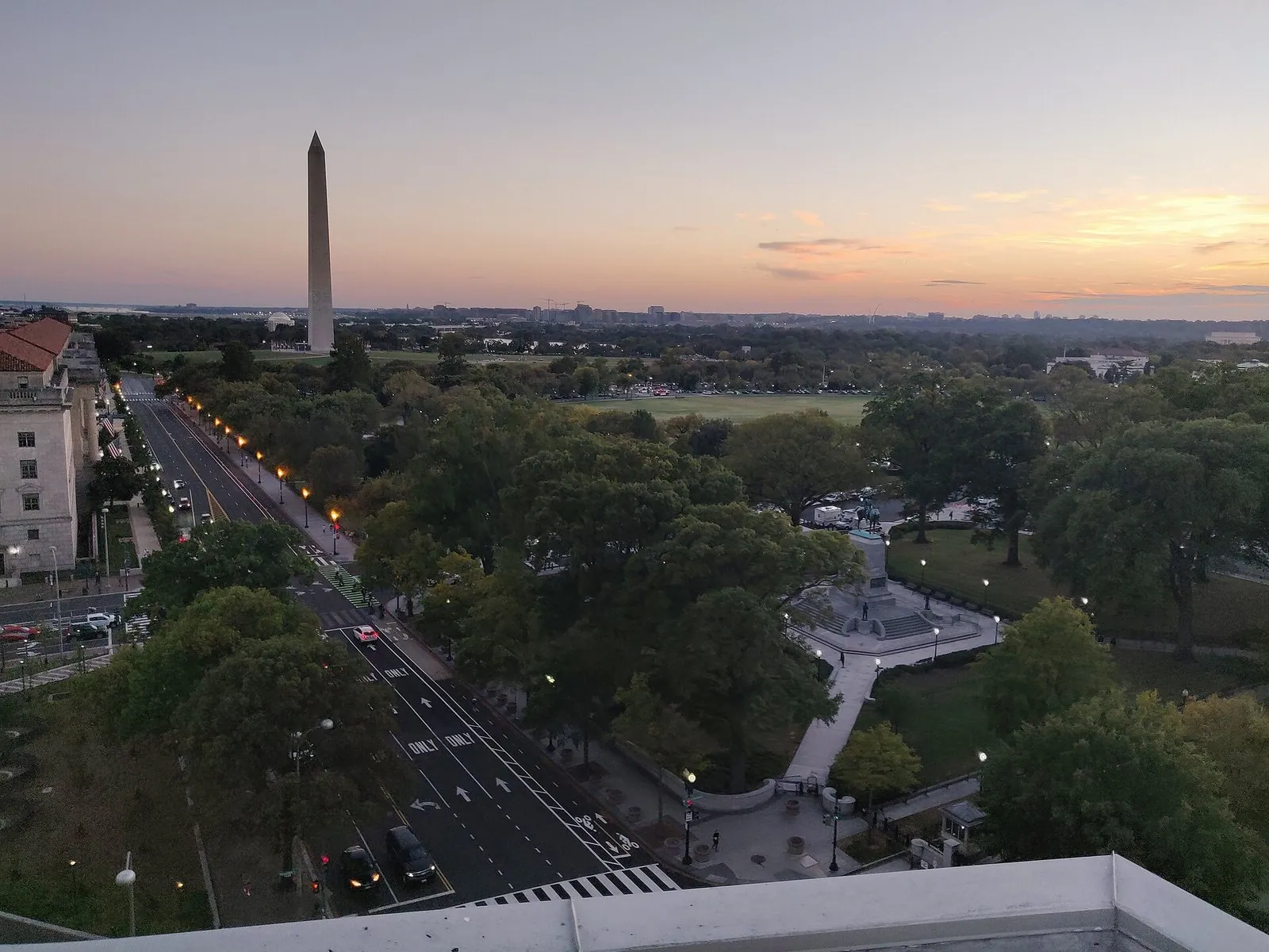 The National Mall and Washington Monument at dusk from a rooftop, the view behind these Washington DC travel tips