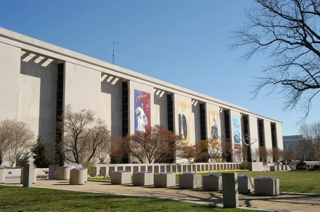 The long modernist facade of the National Museum of American History with exhibition banners, seen from the lawn