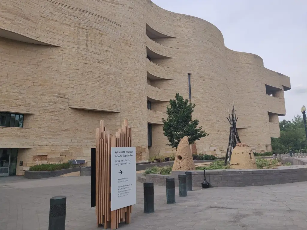 The curving golden limestone walls of the National Museum of the American Indian, with a landscaped entrance path