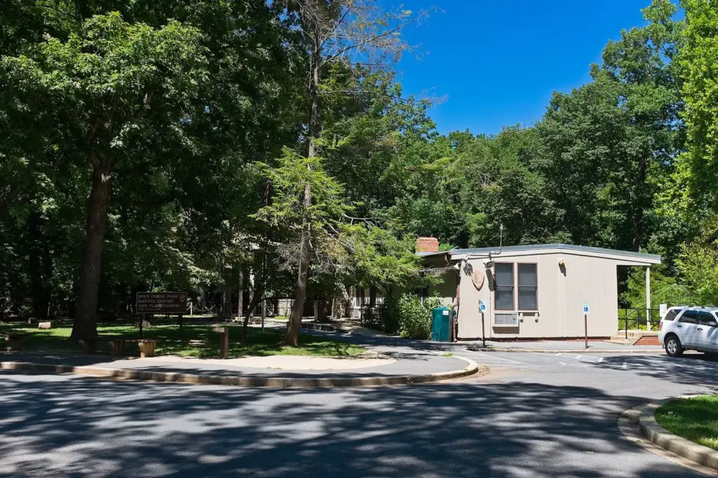 The low Rock Creek Park Nature Center building among tall trees