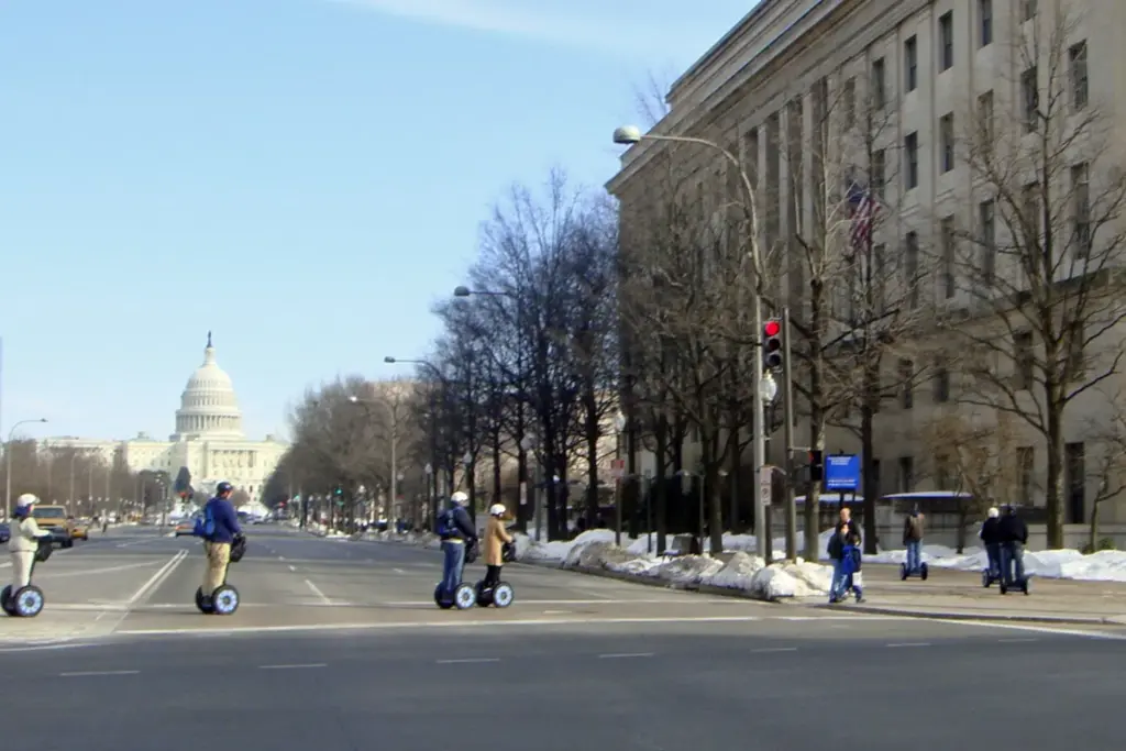 A line of Segway riders crossing Pennsylvania Avenue with the Capitol dome at the end of the street