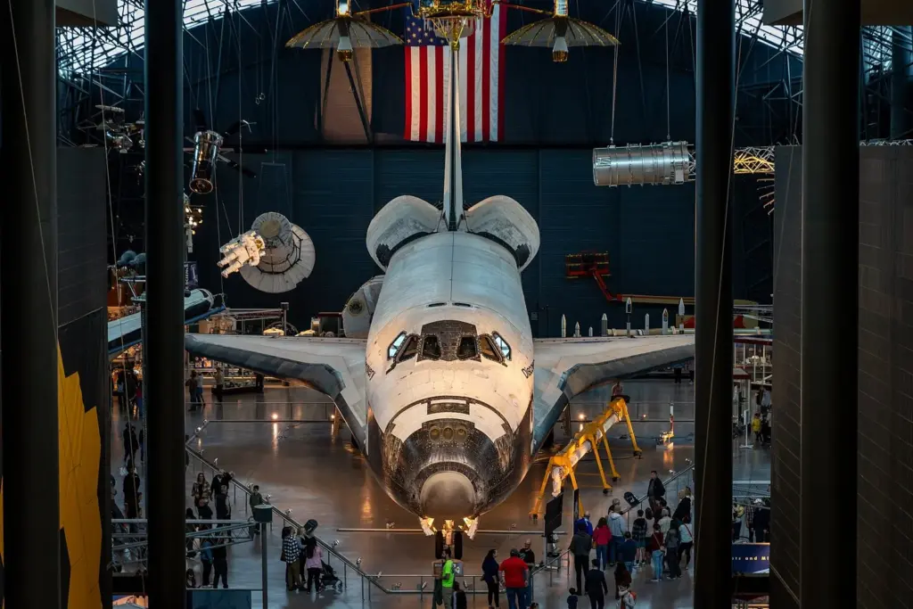 Space Shuttle Discovery displayed nose-first in the hangar of the Udvar-Hazy Center, with spacecraft hanging above