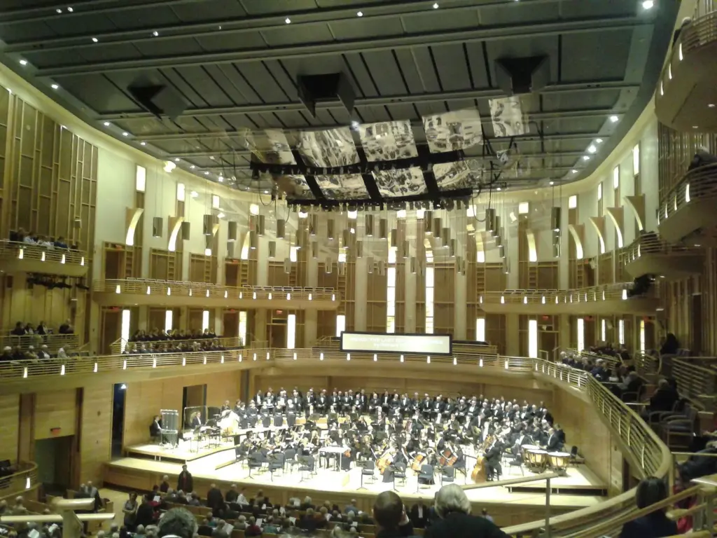 An orchestra on stage in the wood-lined concert hall at the Music Center at Strathmore