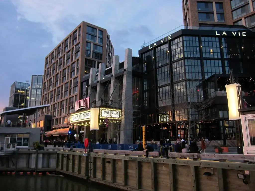 The Wharf's waterfront promenade and music hall marquee at dusk