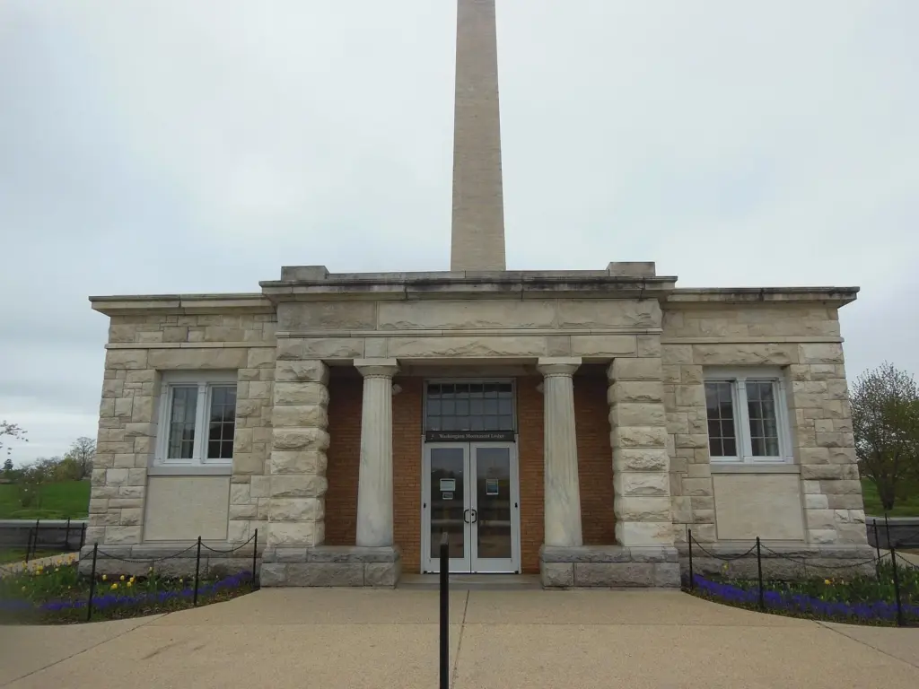 The small stone Washington Monument Lodge on 15th Street with the monument behind it